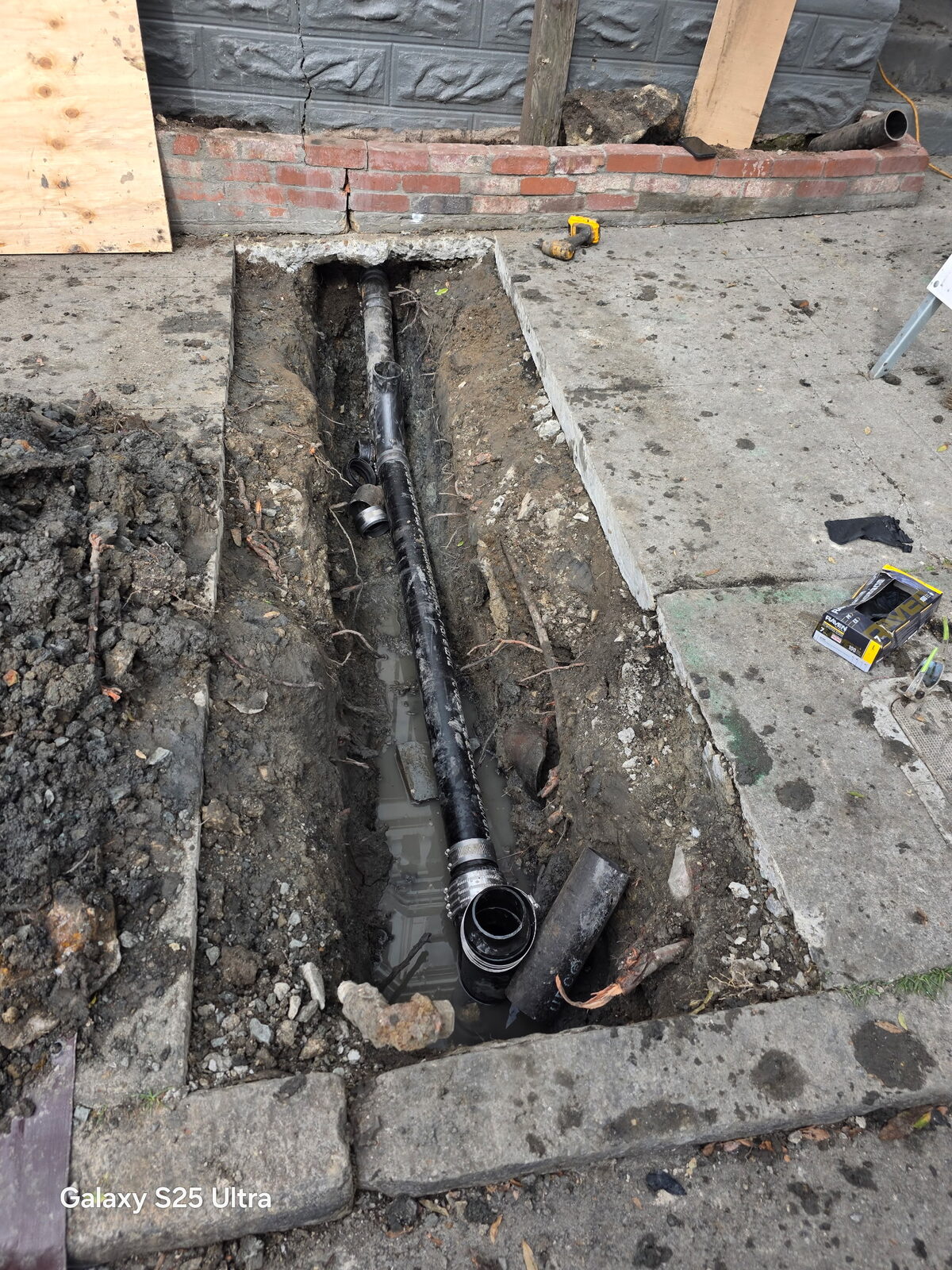 An open sewer lateral trench cut through the sidewalk on the 2200 block of 23rd Street, Potrero Hill